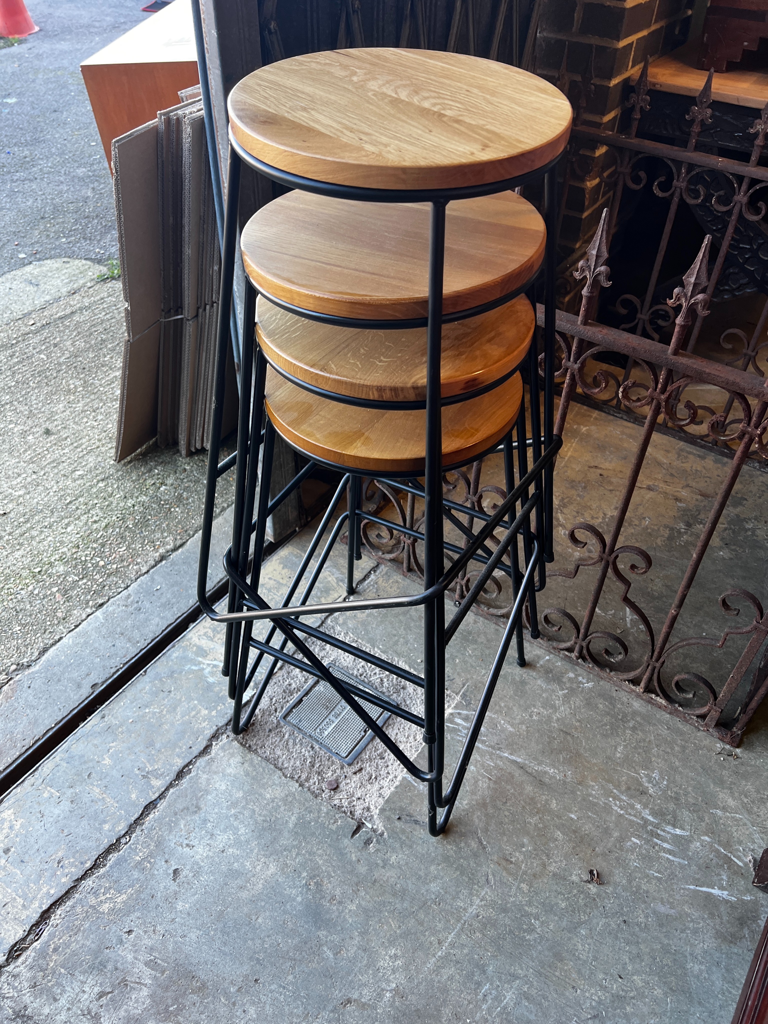 A set of four industrial style wrought iron and oak bar stools, height 70cm